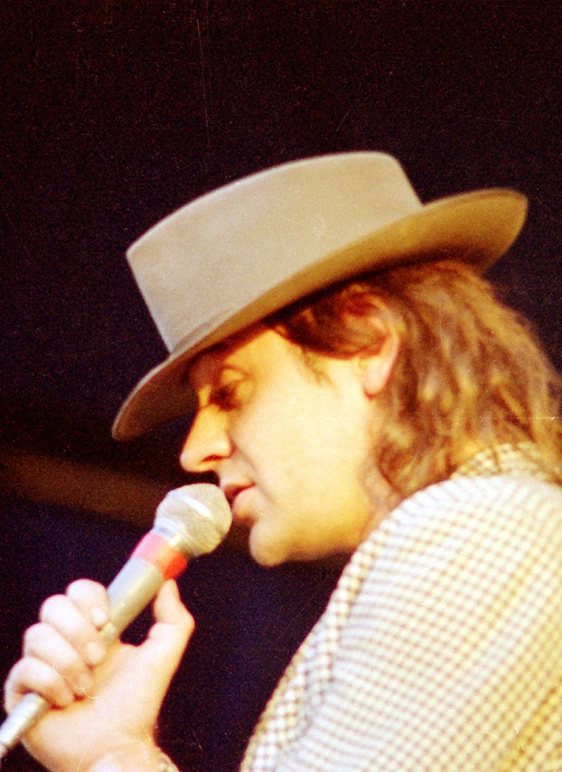Udo Lindenberg singt 1987 im Profil mit hellem Hut in ein Mikrofon.